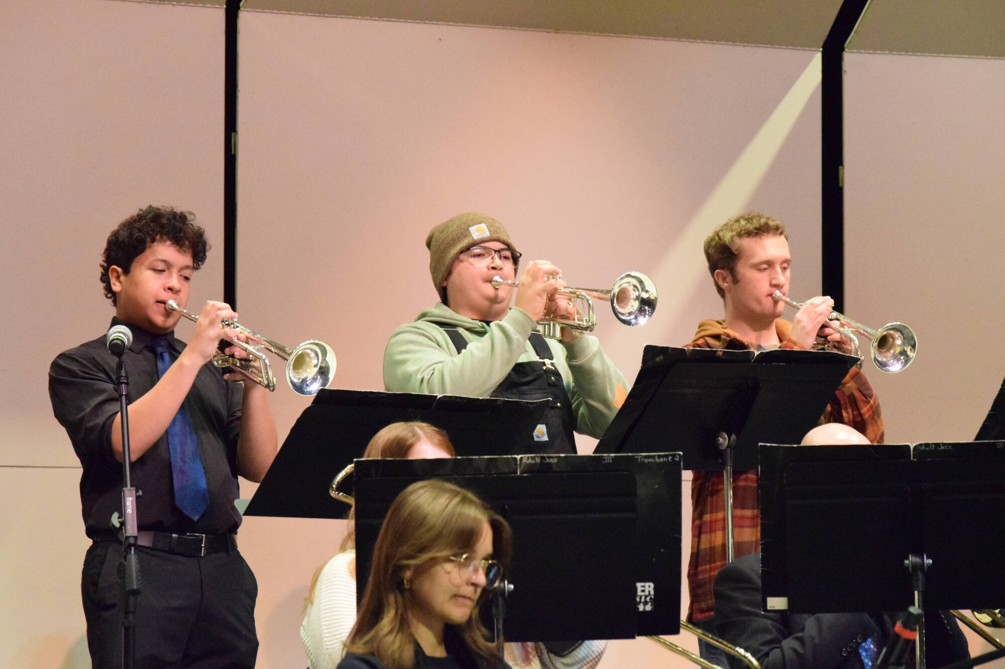 three trumpet players play their trumpets